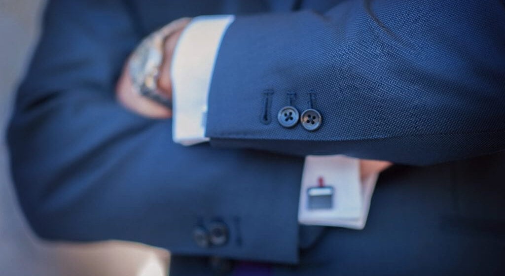 Three jacket sleeve buttons on a navy blue suit