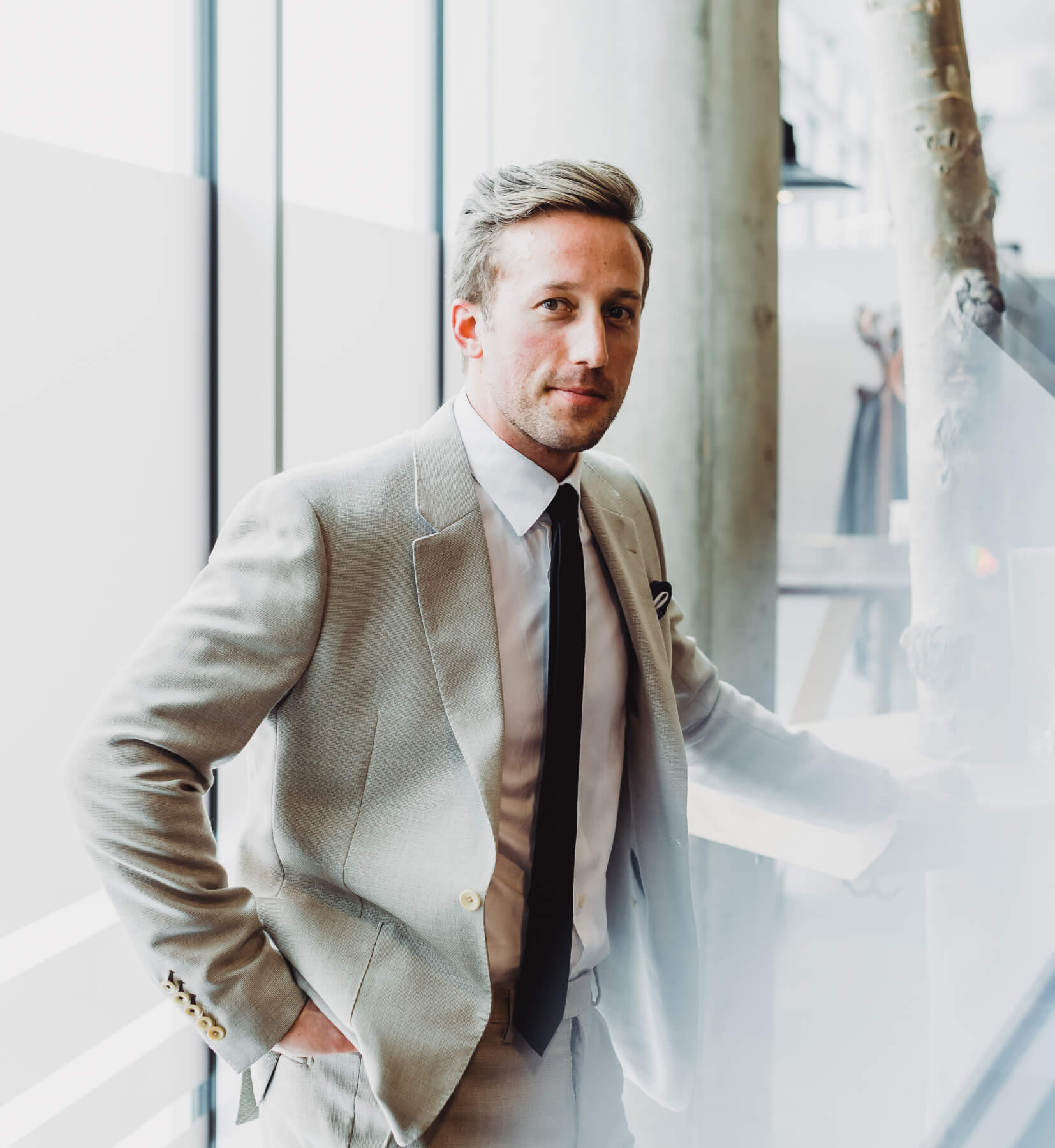 Light gray suit, man standing at bar.